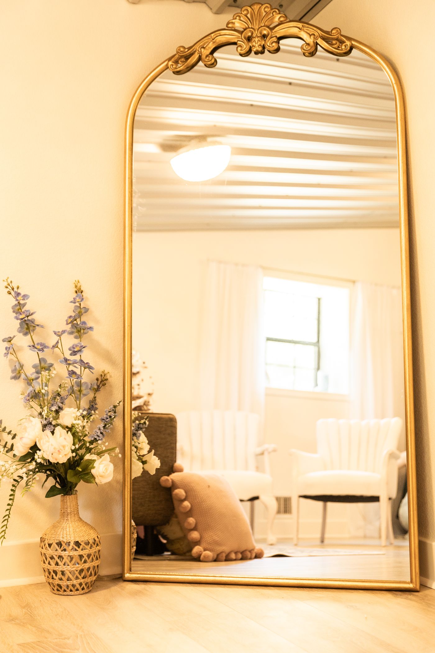 Gold arch mirror with florals in the Heritage Hall bridal lounge