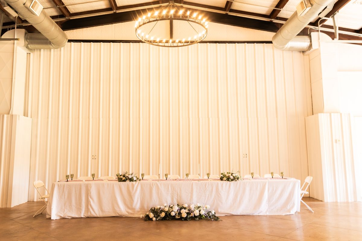 Head table with white linens and florals at Heritage Hall