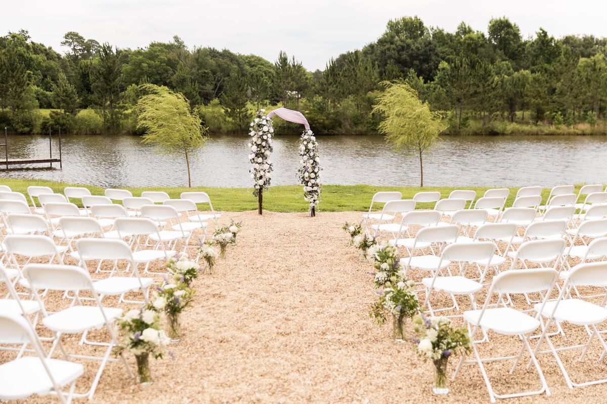Lakeside wedding ceremony aisle lined with white florals
